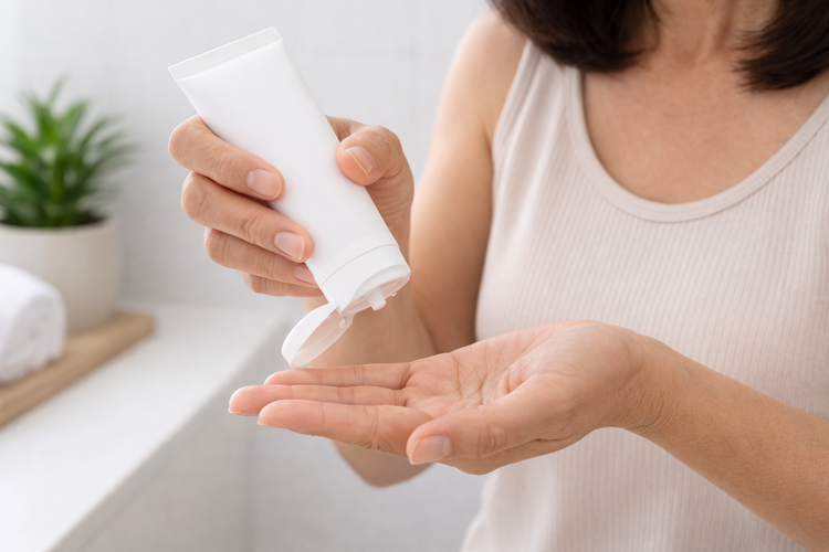 Close-up of a woman applying topical gel as part of menopausal hormone treatment.
