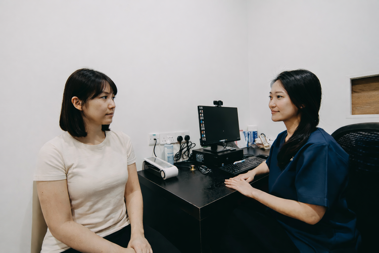 Female patient consulting women’s health doctor about irregular periods in clinic.