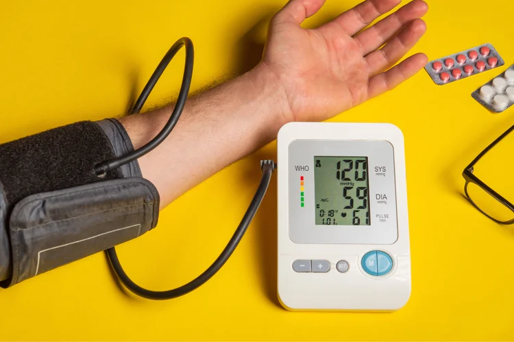 Using a digital blood pressure monitor to check systolic and diastolic readings at home.
