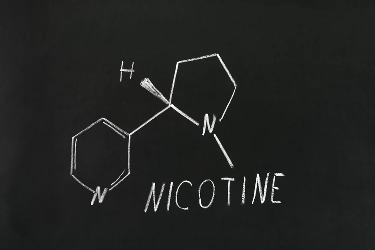 Nicotine chemical structure on a chalkboard, used in cotinine tests for nicotine detection.