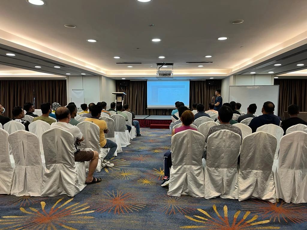 Sinya Industries staff listening to a health talk and presentation by Dr Leonard Leng of ATA Medical inside an auditorium.