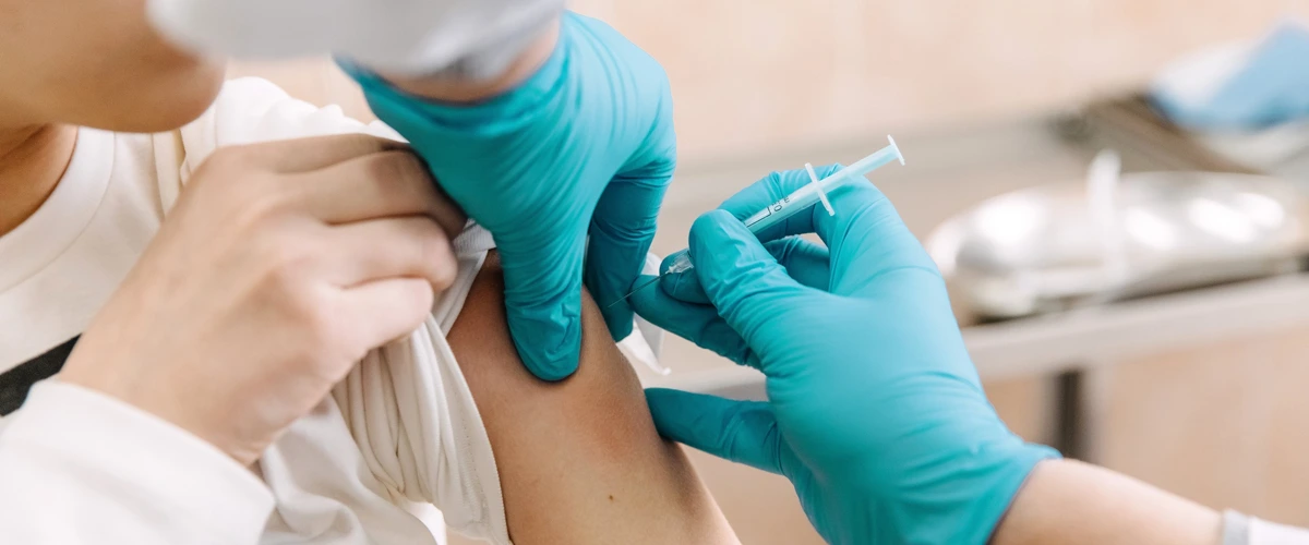 Nurse giving patient a vaccination jab.